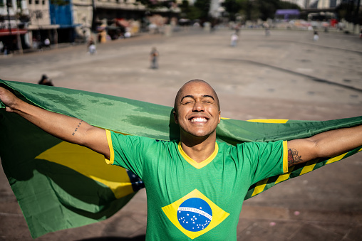 Young man with a brazilian flag outdoors