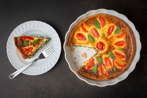 Vegetarian homemade pie, Quiche with tomatoes, spinach and feta cheese, spinach quiche (Turkish name; ispanakli kis)