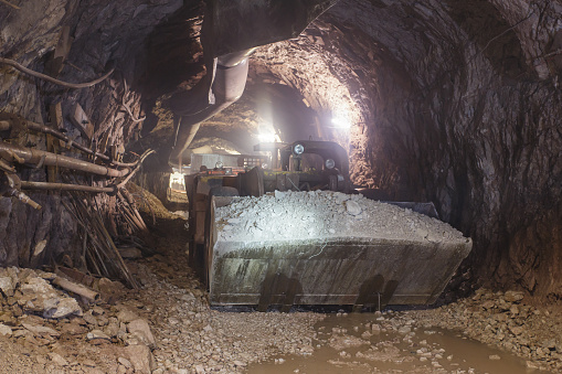 Underground bulldozer. Special load vehicle for mines and tunnels. Iron ore mine as part of steel mill production.