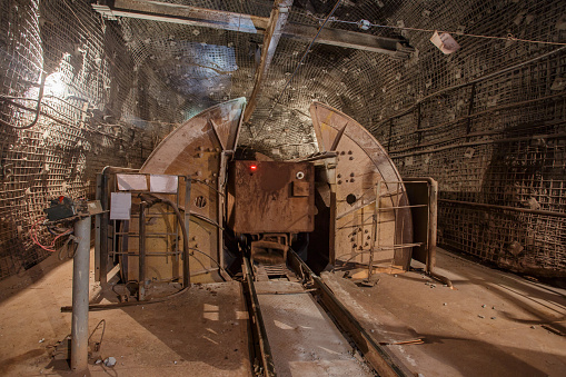 Rotating unloader of railway underground cars. Closeup view in iron ore mine.