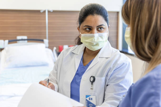 istock Female doctor receives information from unrecognizable nurse 1407170867