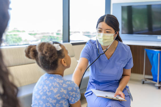 Female doctor talks to girl while using stethoscope for examination The mid adult female doctor talks to the unrecognizable child as she uses a stethoscope for the medical exam. emergency medicine stock pictures, royalty-free photos & images