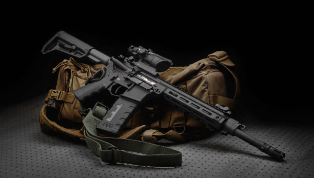 istock A modern automatic carbine with a collimator sight. The weapon lies on a military backpack. Rifle for the police, special forces or the army. Dark background. 1407171614