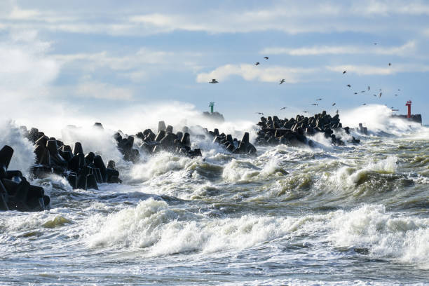 istock Big waves breaking over harbor breakwall concrete tetrapods 1407171665