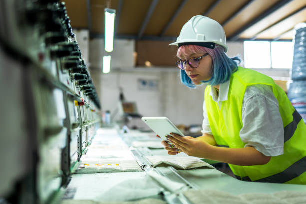 Young female engineer working with manufacturing equipment in a factory stock photo