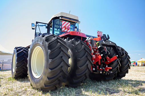 Rostov-on-Don, Russia - 06/10/2022: Close-up rear view of a large modern tractor for agricultural work. Demonstration of new models of agricultural machinery at the Day of the Field exhibition in 2022.