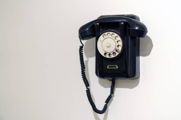 istock An old black analog phone made of ebony hangs on the wall 1407174596