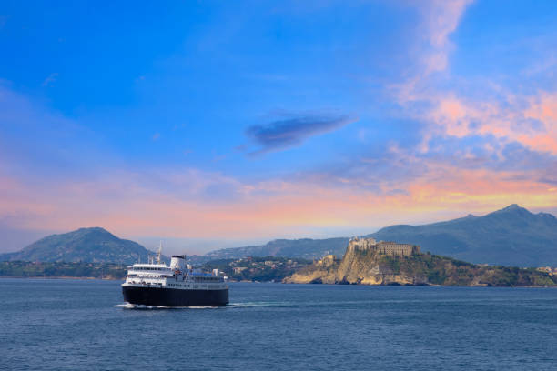 istock Italy, scenic sunset over Procida Island near Naples with boat approaching it from afar 1407175721