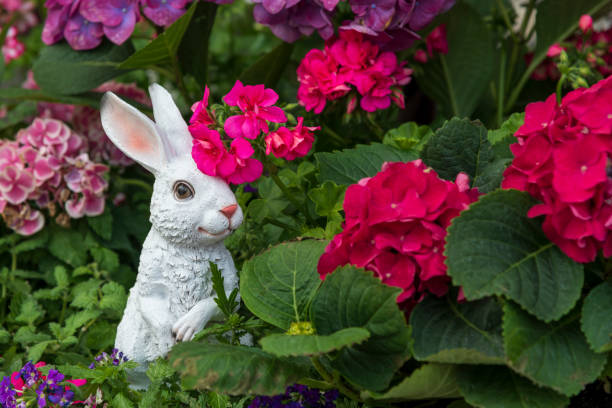 istock white rabbit stands by colorful flowers 1407177191