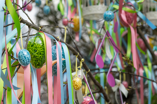 many colorful painted easter eggs on apple tree as easter decoration