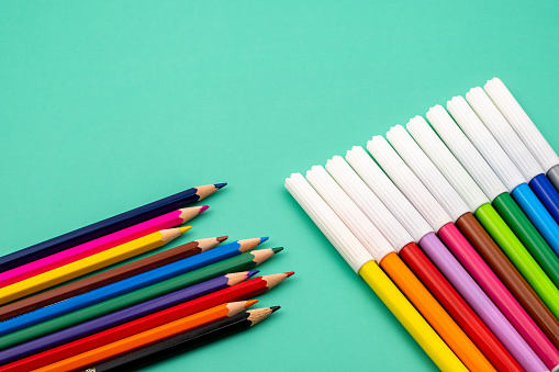 Colorful crayons sitting over blue background. Horizontal composition with copy space.