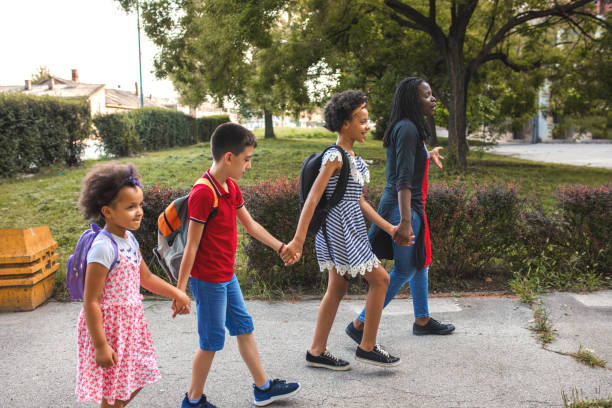 istock Black woman taking three kids to school 1407182563