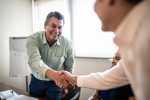 istock Coworkers greeting and doing a handshake at work 1407182786