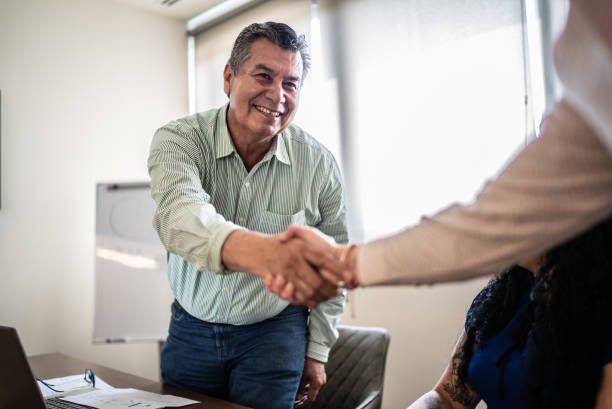 istock Coworkers greeting and doing a handshake at work 1407182787
