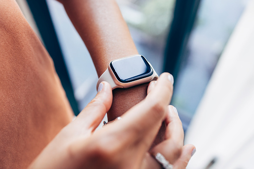 Close up shot of an anonymous woman checking time on her digital watch.