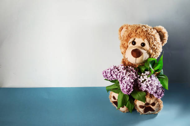 teddy bear with a bouquet of lilacs