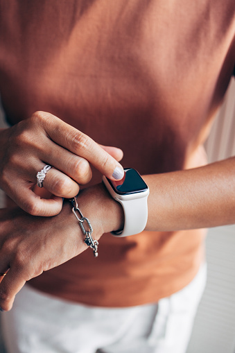 Close up shot of an anonymous woman checking time on her digital watch.