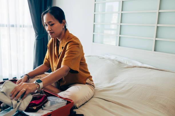 istock Asian Woman Packing Her Suitcase 1407182873