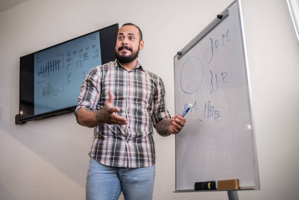 istock Mid adult businessman doing a presentation at work 1407184022