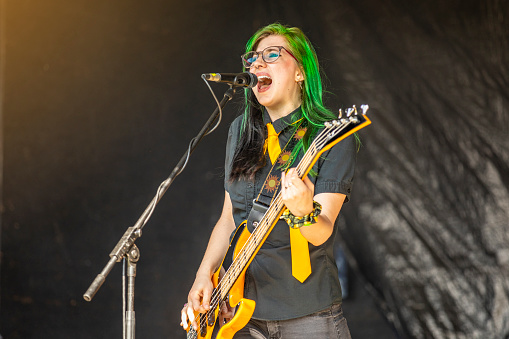 A beautiful 20 year old with green hair singing and playing bass live with her pop punk band.