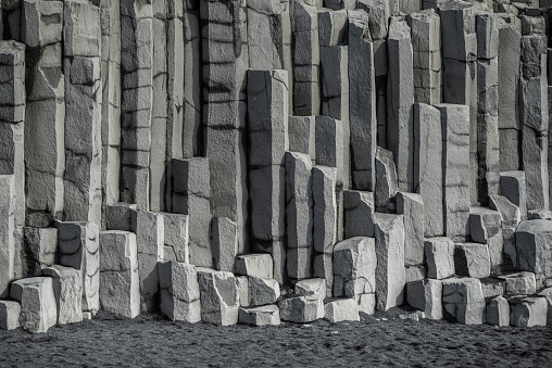 The vertical basalt columns at Reynisfjara, the famous black beach in Iceland, near Vík í Mýrdal, form a perfect geometric background pattern