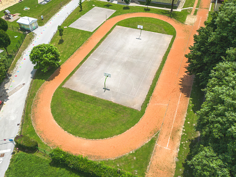 Aerial view of a sports athletic and recreational centre or stadium with basketball court, football field, beach volley and running tracks.