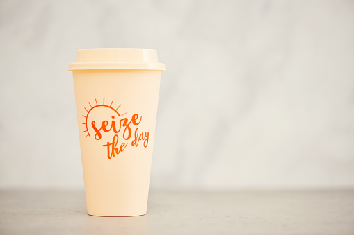 Reusable coffee cup in bright setting with space for text