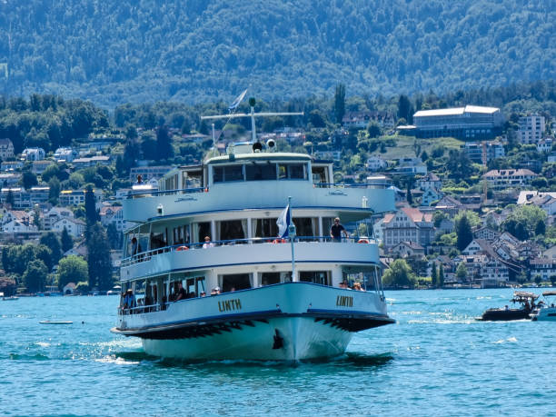 Küsnacht, Switzerland - July 3, 2022: The boat Linth on Lake Zurich is going to berth on the pier of Küsnacht.