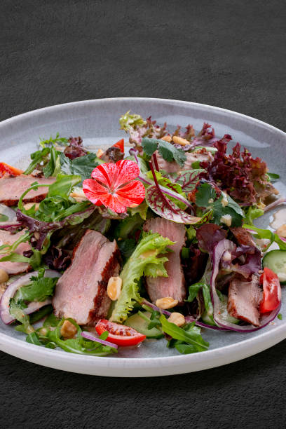 istock Josper-oven veal salad with sauce. On a dark background, isolated. 1407187892
