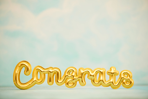 CONGRATULATIONS message in gold against blue sky with lots of space for copy