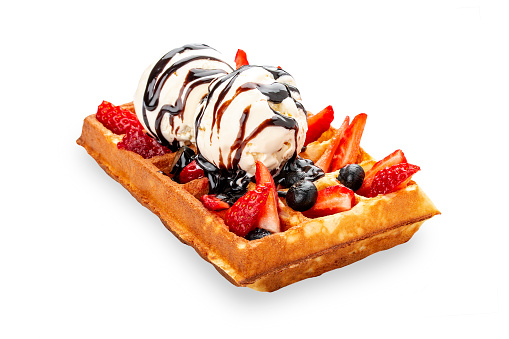 Belgian sweet waffle. With ice cream balls, strawberries and blueberries. On a white background, isolated.