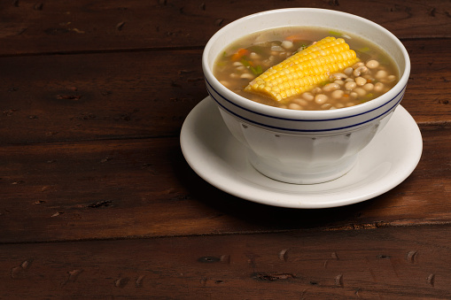 Delicious soup of white beans with ingredients as sweet corn,carrot and slice of carrots.