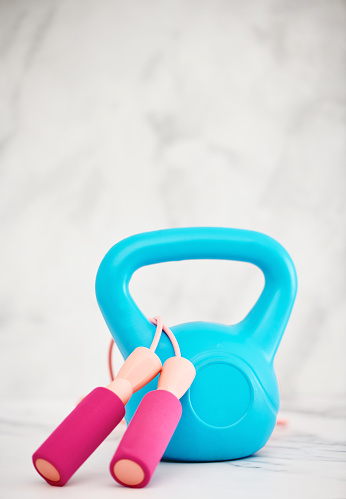 Kettlebell and skipping rope in a bright setting with space for copy