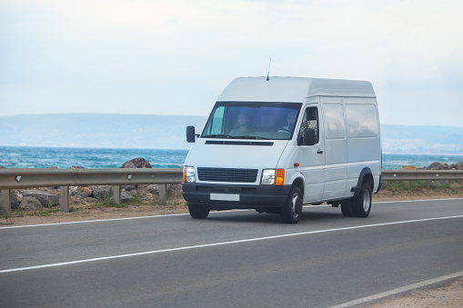 minibus moves along the road along the sea coast