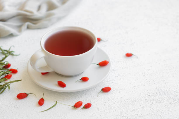 istock Cup of herbal goji berry tea with fresh goji berries on rustic table 1407194984