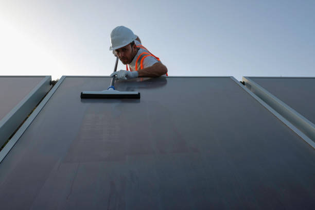 istock worker with personal protective equipment cleaning solar panels . 1407196133