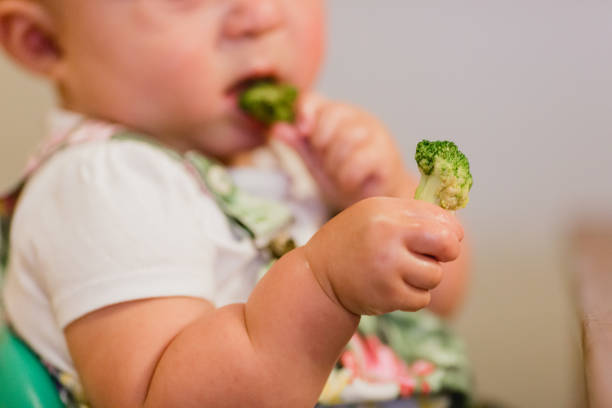 istock Baby Girl Eating Vegetables 1407206576