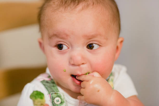 istock Baby Girl Eating Vegetables 1407206582