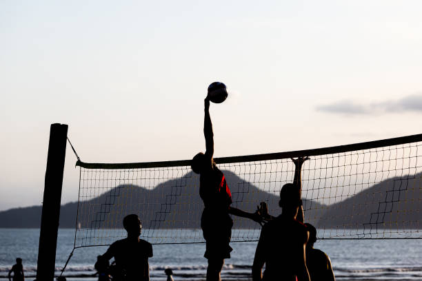 jóvenes jugando voleibol de playa en santos, brasil - volleyball volleying human hand men fotografías e imágenes de stock