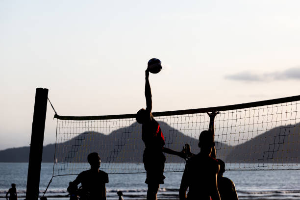 young people playing beach volleyball in santos, brazil - volleyball volleying human hand men imagens e fotografias de stock