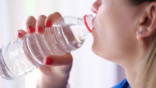 istock Woman drinking water from plastic bottle closeup 1407209242