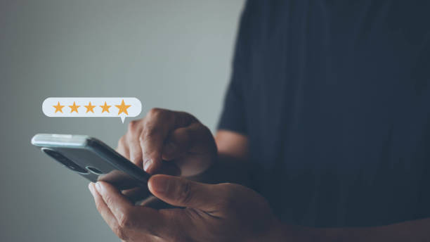 istock Man hand using smartphone with popup five star icon for feedback review satisfaction service on blur background, Customer service experience, and business satisfaction survey. 1407212395