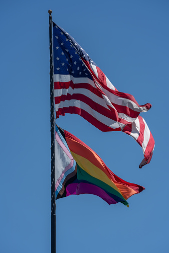 American and Rainbow Flag flying together during Pride Month