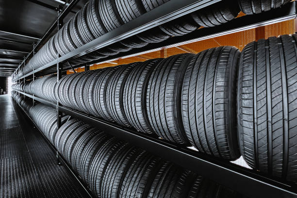 l'immagine panoramica di un nuovo pneumatico viene posizionata sul rack di stoccaggio dei pneumatici nell'industria dei pneumatici. preparati per i veicoli che devono cambiare le gomme. - tire foto e immagini stock