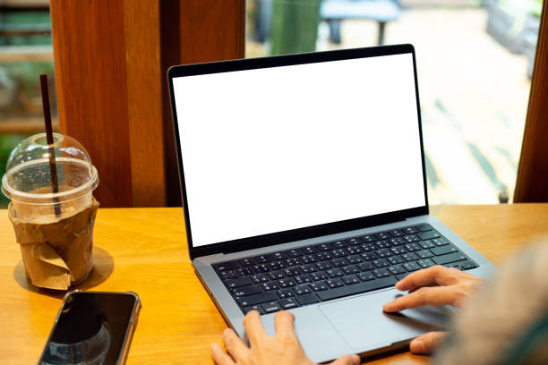 istock mock up empty screen notebook, businesswoman working on his laptop computer with blank space screen for advertising text on wood desk in Cafe 1407219949