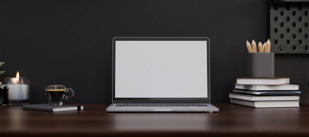 istock Modern dark stylish workspace with notebook laptop on dark wood table over the black wall. 1407221218