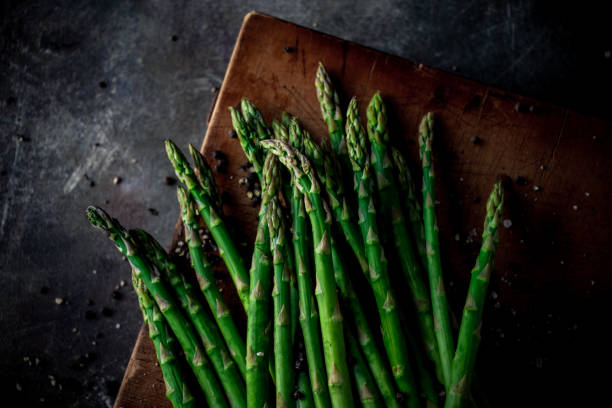 istock Fresh green asparagus on wooden cutting board. 1407223688