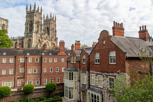 This image shows a cityscape view of York, England from atop the medieval city stone walls, which have foundations originally dating back to the time of the Romans.