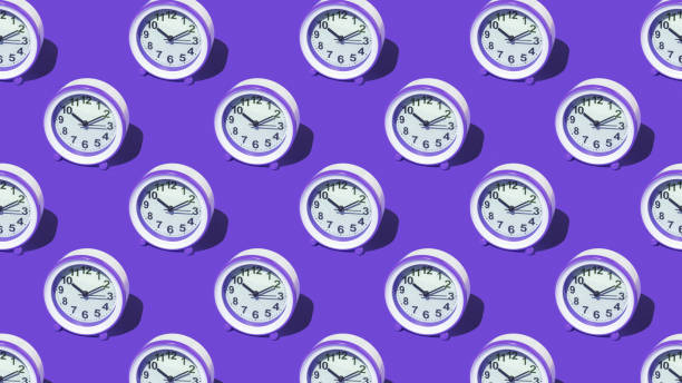 istock A pattern of purple alarm clocks on a purple background. 1407224831