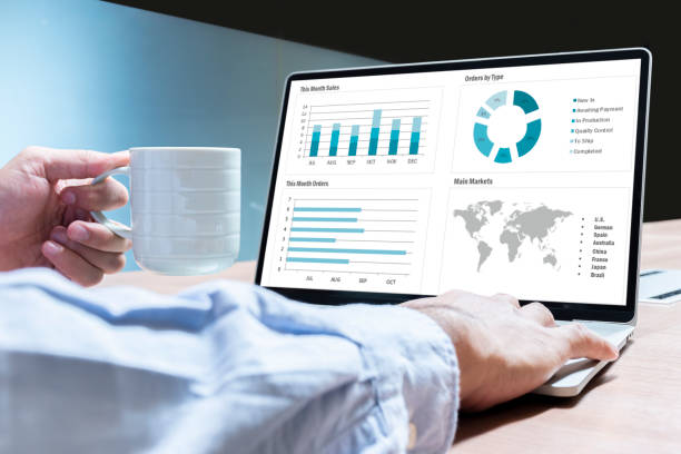Businessman hand holding coffee cup with mockup chart presentation slide show on display laptop
